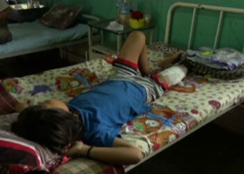 Girl, wounded by snare-trap, being treated